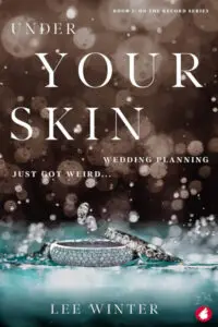Book cover for "Under Your Skin: Book 2: On the Record Series - Wedding Planning Just Got Weird..." by Lee Winter. The image features two ornate rings, one a wide band covered in small gems and the other a more traditional diamond-set band, lying in or on the surface of blue-tinged water, with splashes and droplets around them. The background is a dark, blurred bokeh effect with numerous out-of-focus lights and falling particles, creating a sense of mystery or magic. The title "UNDER YOUR SKIN" is in large white serif font at the top, with "WEDDING PLANNING JUST GOT WEIRD..." in smaller white text below it. The author's name, Lee Winter, is in white text at the bottom.