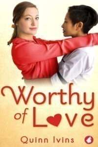 A book cover for "Worthy of Love" by Quinn Ivins. The top half of the cover features two women embracing. One woman with light brown hair in a ponytail and a red shirt looks directly at the viewer with a soft smile, while the other woman with dark, short hair, wearing a white shirt, looks at her. The background behind them is a soft, light yellow to white gradient. The title "Worthy of Love" is in large, flowing red script, with a red heart substituting for the "o" in "Love." The author's name, Quinn Ivins, is in red text at the bottom.